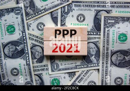 PPP, paycheck protection program 2021 symbol. Concept words PPP, paycheck protection program 2021 on wooden blocks on a beautiful background from doll Stock Photo