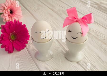 Easter composition with white eggs in white coasters on a white wooden background. Closeup. Stock Photo