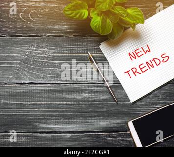 New trends concept. Desktop with notebook, phone, pen. The concept of searching for new ideological trends and tendencies. Exclusive trend. Popular an Stock Photo