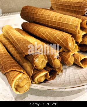 Appetizing wafer rolls with boiled condensed milk. Delicious homemade sweets. Stock Photo