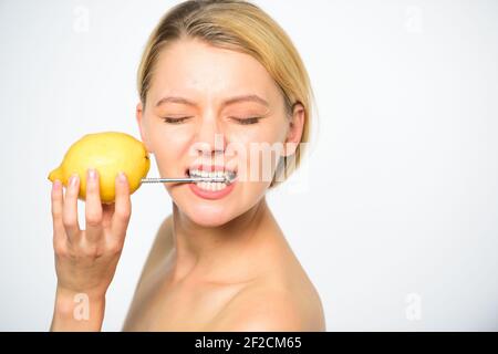 Lemon with hobnail natural battery. Recharge your body vitamins. Girl drink fresh juice whole lemon fruit. Energy source and vitality. Battery concept. Nutritious drink fill with energy. Stock Photo