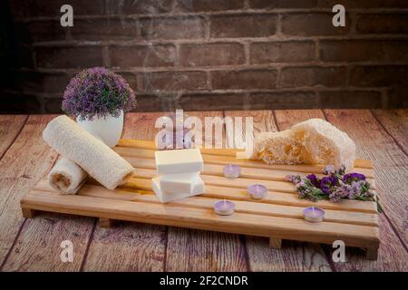 Beautiful spa composition with natural soaps with scented candles and bathroom accessories in a romantic setting for a cleansing concept. Stock Photo