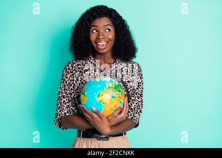 Photo of excited lady hug globe look up empty space wear leopard print shirt isolated teal color background Stock Photo