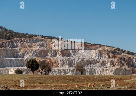 Rock quarry mining for gravel and limestone with blast marks showing on the sides of steep walls Stock Photo