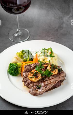 Delicious juicy grilled steak and shrimp with grilled broccoli and cauliflower.  Surf and Turf style. Stock Photo