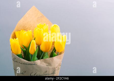 Bouquet of yellow tulips on a gray background with place for text. Stock Photo