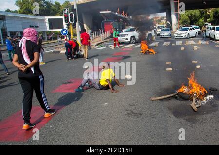 Johannesburg, South Africa. 10th Mar, 2021. Students block traffic during the demonstration.South African police moved to disperse students protesting against refusal by Wits University to register those students in arrears with tuition fees. Police Clashed with protesters who were blocking the roads with rubble and disrupting traffic in Johannesburg. Credit: Thabo Jaiyesimi/SOPA Images/ZUMA Wire/Alamy Live News Stock Photo