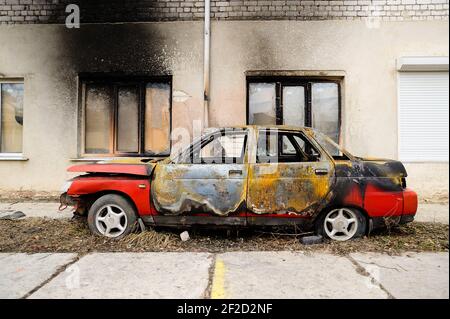 Burnt red car after fire accident side view Stock Photo