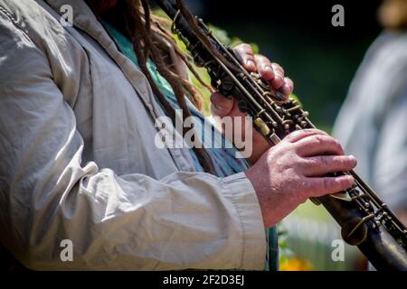 Close-up of the hands of a man playing the clarinet in the street Stock Photo