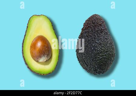 Fresh ripe opened avocado fruit isolated on blue background. Top view Stock Photo