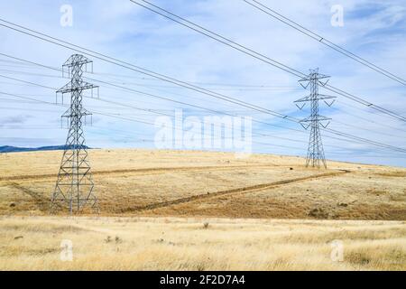 Power lines crossing above arid land in Kittitas County in Central Washington State Stock Photo