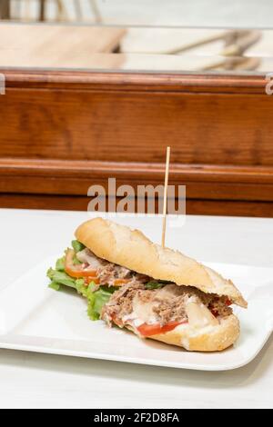 Tuna salad with mayo baguette on a white tablecloth in a restaurant Stock Photo