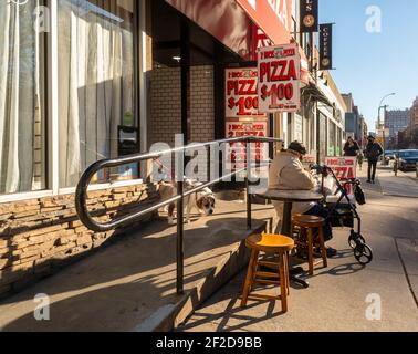 Elderly man with his walker sits in front of a dollar pizzeria in Chelsea in New York on Tuesday, March 2, 2021.  (© Richard B. Levine) Stock Photo