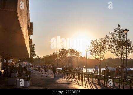 BELGRADE, SERBIA - AUGUST 29, 2020: people working out, biking and riding electric scooter and running on a pedestrian waterfront of the Danube quay i Stock Photo