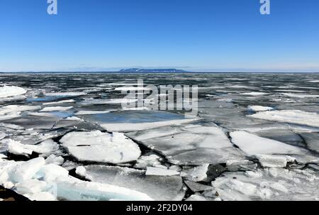 Spring breakup on a sunny day of  Lake Superior winter ice, with the 'Sleeping Giant' Provincial park in the distance. Stock Photo