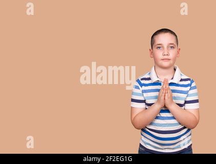 Calm boy praying to God with hands held together. Gratitude day Stock Photo