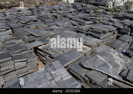 raw slate piled neatly ready for cutting into roof tiles Stock Photo
