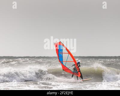 Garrylucas, Cork, Ireland. 11th March, 2021. In the aftermath of an overnight storm a winsurfer takes advantage of the high winds and rough seas at Garrylucas, Co. Cork, Ireland.  - Credit; David Creedon / Alamy Live News Stock Photo