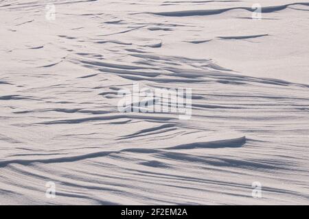 Random patterns in sparkling white snow created by the wind Stock Photo