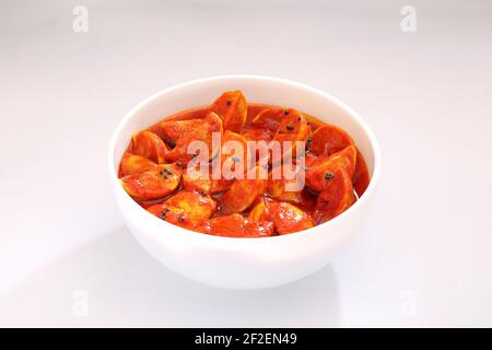 Lemon pickle,hot and sour  red lime pickle arranged  in a white bowl  with   white textured  background. Stock Photo
