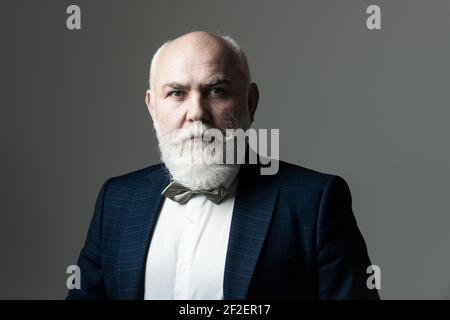 Portrait of a bearded middle-aged man over a gray studio background with copyspace. Serious Senior Man.