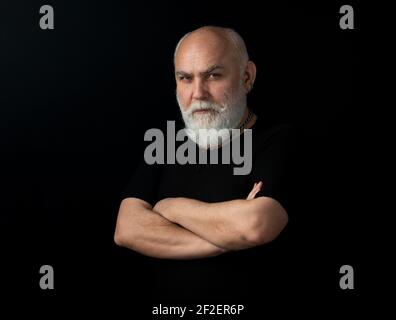 Bearded middle-aged man with a serious expression in a closeup head and shoulders portrait.