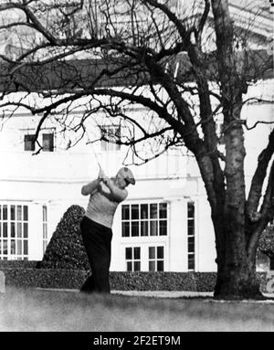 President Dwight Eisenhower Swings a Golf Club on the South Lawn of the White House. Stock Photo