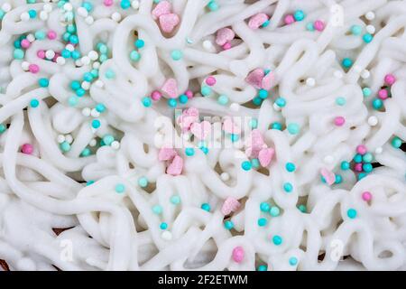 The texture of icing on a cake with pastry sprinkles, macro photography. Stock Photo