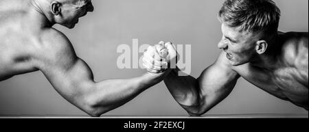 Arm wrestling. Two men arm wrestling. Rivalry, closeup of male arm wrestling. Two hands. Men measuring forces, arms. Hand wrestling, compete. Hands or Stock Photo