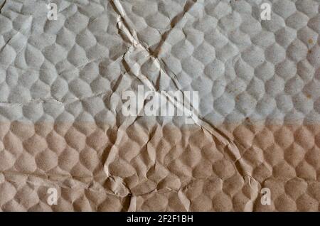 Two-tone old crumpled honeycomb cardboard. Pressed paper packaging cells. Abstract textured background. Stock Photo