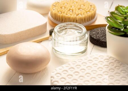 Natural organic cosmetic products and bathroom accessories on white background. Soap bar, gel cream, cotton sponges, massage brush close up. Stock Photo