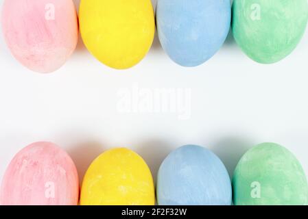 Colorful Easter eggs double border over a on white background. Row of Easter eggs. Top view, copy space Stock Photo