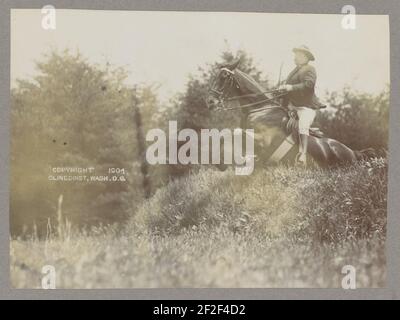 President Theodore Roosevelt on horseback jumping over grass Stock Photo