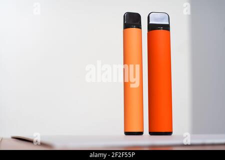 two disposable e-cigarettes on a yellow background. The concept of modern smoking, vaping and nicotine. Top view Stock Photo