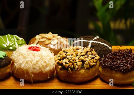 Colorful homemade mini donuts in shallow focus  with dark background Stock Photo