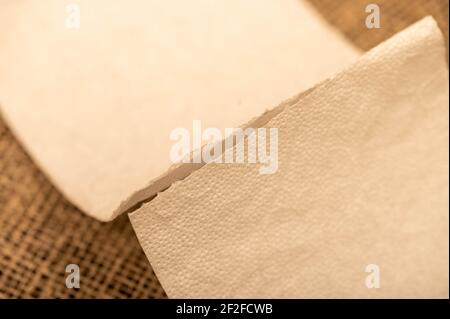 Paper napkins on a background of homespun fabric with a rough texture. Close-up, selective focus. Stock Photo