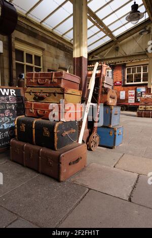 Stack of old battered suitcases on the station platform in Llangollen North Wales Stock Photo