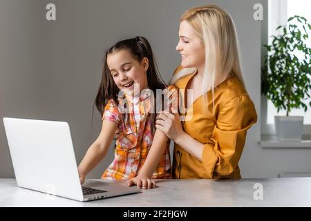 Helpful mother explaining to daughter about using a laptop Stock Photo
