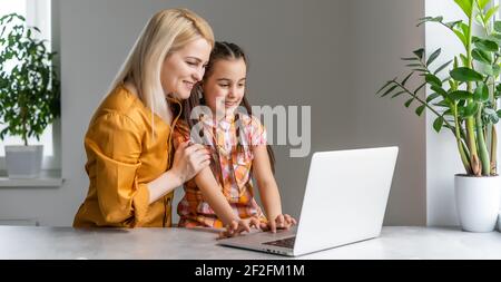 Helpful mother explaining to daughter about using a laptop Stock Photo
