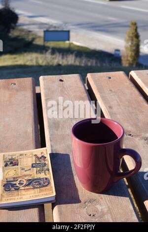 Coffee Mug and Small Notebook on Wooden Desk Outdoor Stock Photo