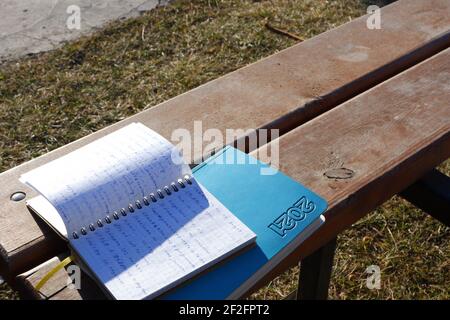 Opened notebook and Agenda on Wooden Bench Stock Photo