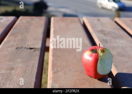 Bitten Red apple on wooden table outdoor Stock Photo