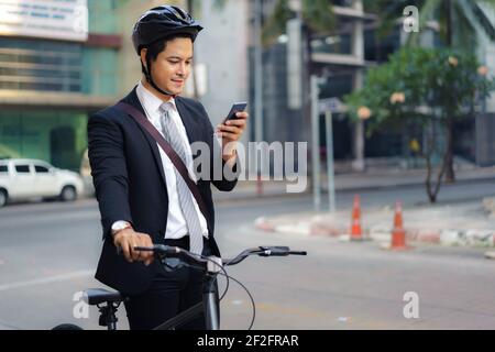 Asian businessman using their mobile phones to view applications, maps, directions to work in the morning. Stock Photo