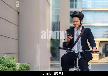 Asian businessman using their mobile phones to view applications, maps, directions to work in the morning. Stock Photo