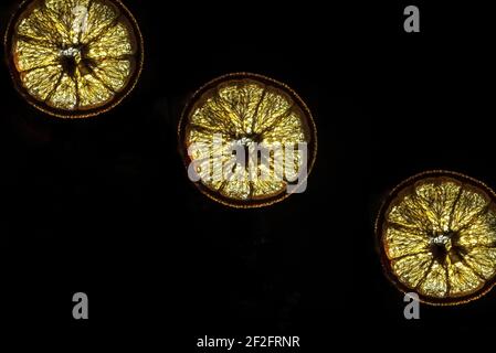 Dried orange slices on a black background, close up, isolated, back light Stock Photo