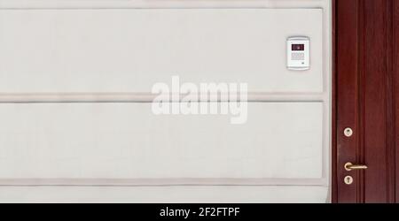 brown wooden front door with light  rustication stone facade building exterior with intercom for security, nobody. Stock Photo