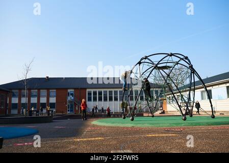 Kids playing on a playground at a school Stock Photo