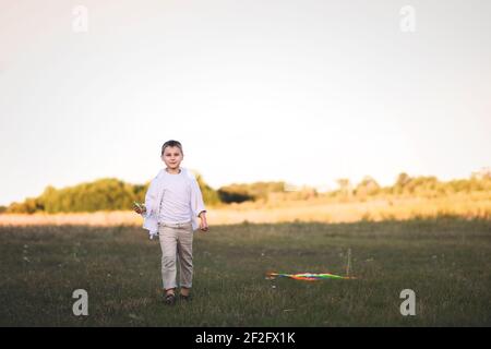 A boy walks on the grass in a rural landscape. Stock Photo