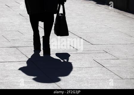 Black silhouette and shadow of lonely woman walking on a street. Female ...