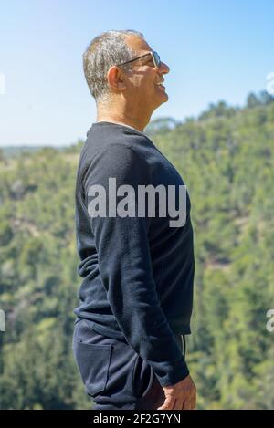 Happy senior man traveler looking at nature. Portrait of healthy smile senior elderly old man grandfather outside. Stock Photo